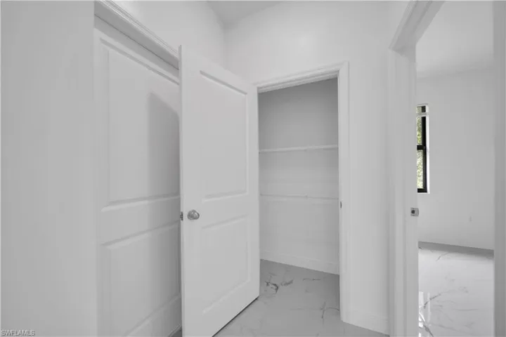 Interior hallway featuring a storage closet with wire shelving and a separate room entrance