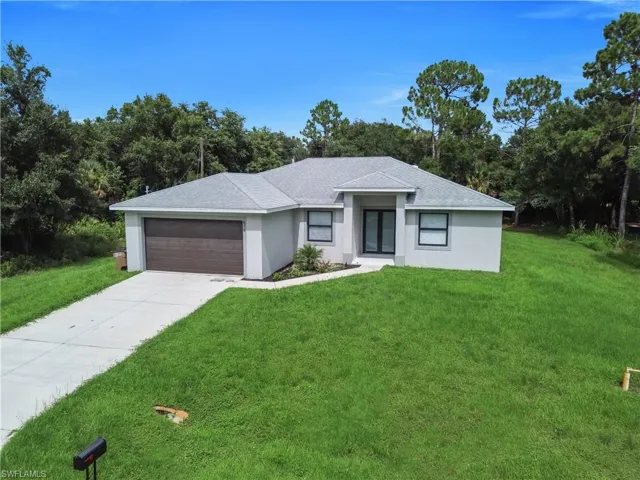 Contemporary single-story residence with a gray exterior finish and a dark wood-finish garage door