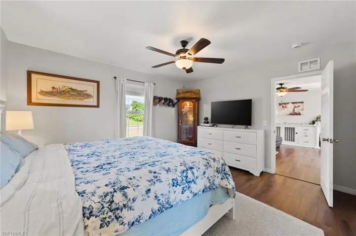 Bedroom featuring visible vents, ceiling fan, baseboards, and dark wood-style floors