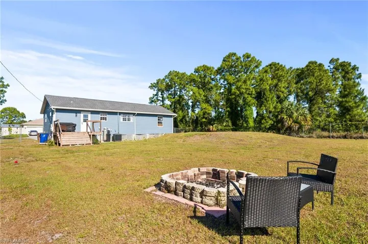 View of yard featuring an outdoor fire pit and a wooden deck
