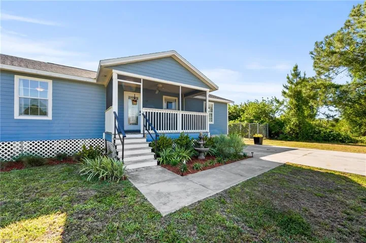 Bungalow featuring fence, a ceiling fan, a front lawn, and covered porch