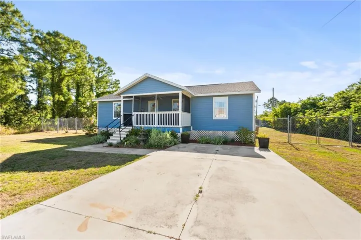 Bungalow-style house with a gate, driveway, a front yard, a sunroom, and fence