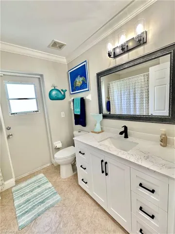 New wood vanity, mirror, light fixture, and faucet.