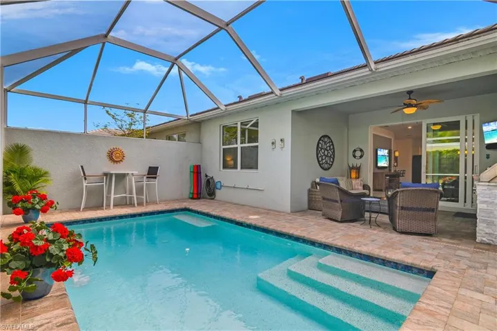 Outdoor pool featuring a lanai, lounge area and sunset kitchen
