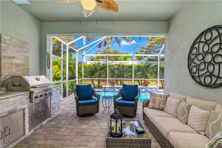View of lanai, screened enclosure, ceiling fan, pool, and a sunset kitchen and conversation area