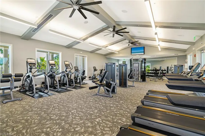 Gym featuring ceiling fan and beam ceiling