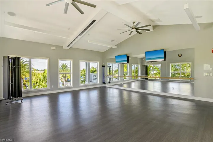 Unfurnished living room with ceiling fan and dark wood-style flooring