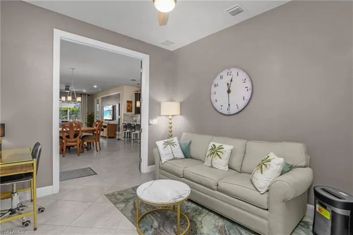 Den featuring tile patterned floors and ceiling fan