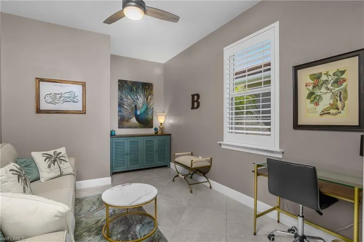 Den area with baseboards and ceiling fan