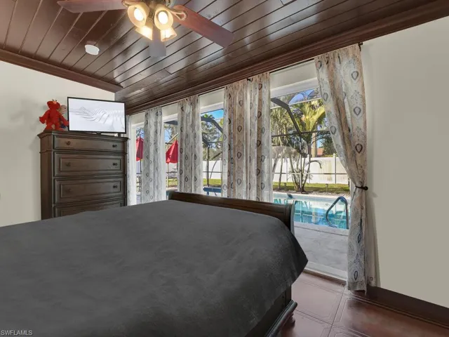 Unfurnished bedroom with access to exterior, ceiling fan, wooden ceiling, and vaulted ceiling