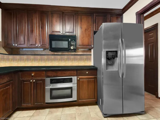 Kitchen featuring dark brown cabinetry, ornamental molding, backsplash, and appliances with stainless steel finishes