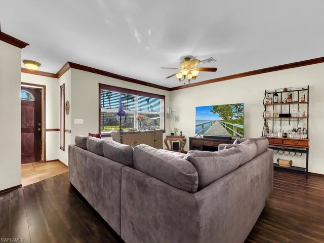 Living room featuring ceiling fan, hardwood / wood-style floors, and ornamental molding