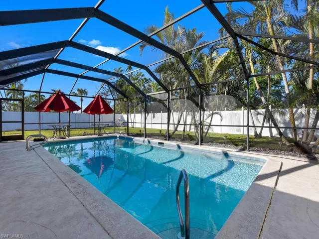 View of pool featuring glass enclosure and a patio area