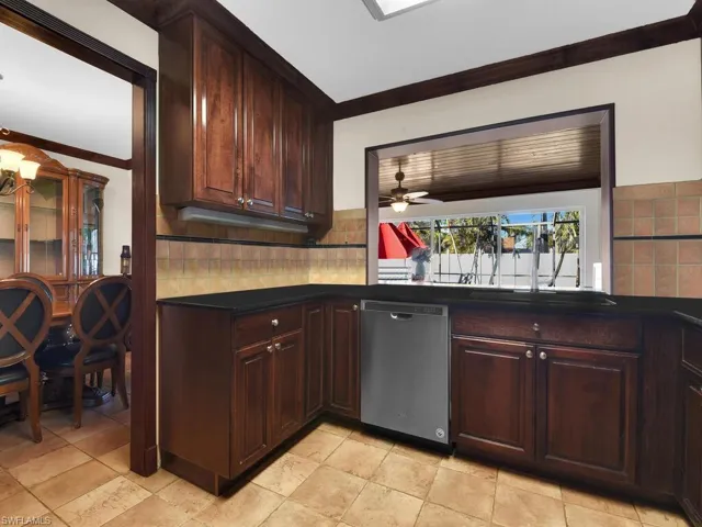 Kitchen with ceiling fan, dishwasher, crown molding, and dark brown cabinets