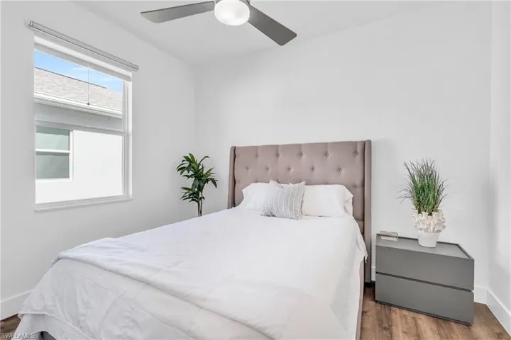 Bedroom with dark wood-type flooring and ceiling fan
