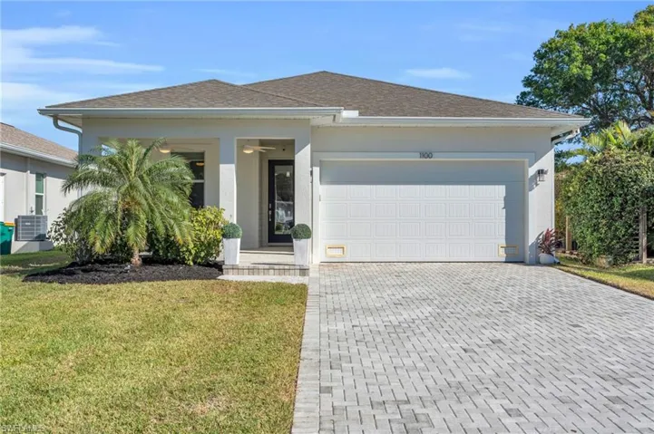 View of front of house with a garage and a front yard
