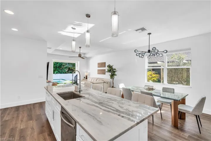 Kitchen with white cabinetry, an island and pendant lighting