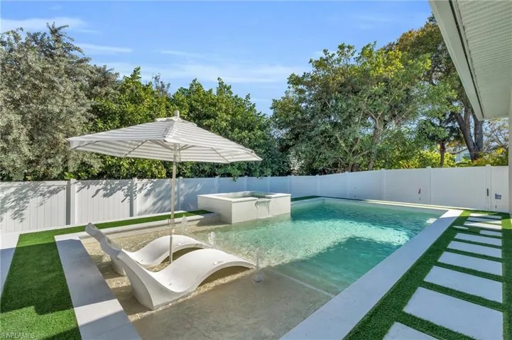 View of pool sundeck perfect for lounging either with full sun or shaded by the inset pool umbrella