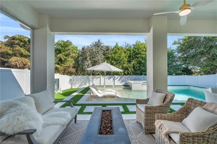 View of patio / terrace with a fenced in pool, ceiling fan, and an outdoor fire pit
