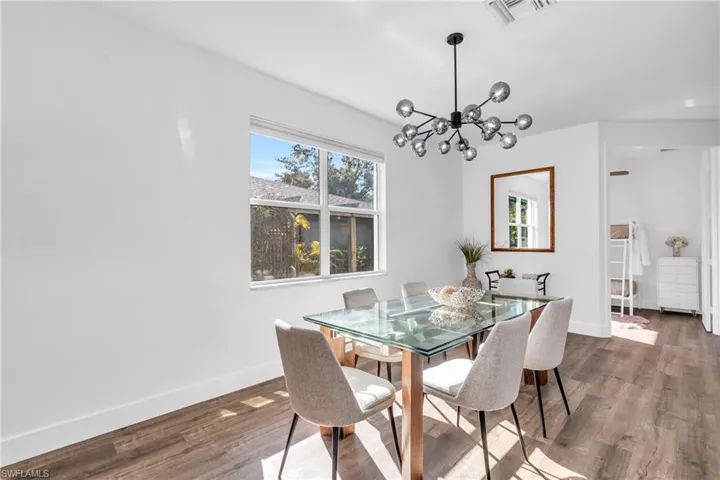 Dining space featuring dark wood-type flooring and an inviting chandelier