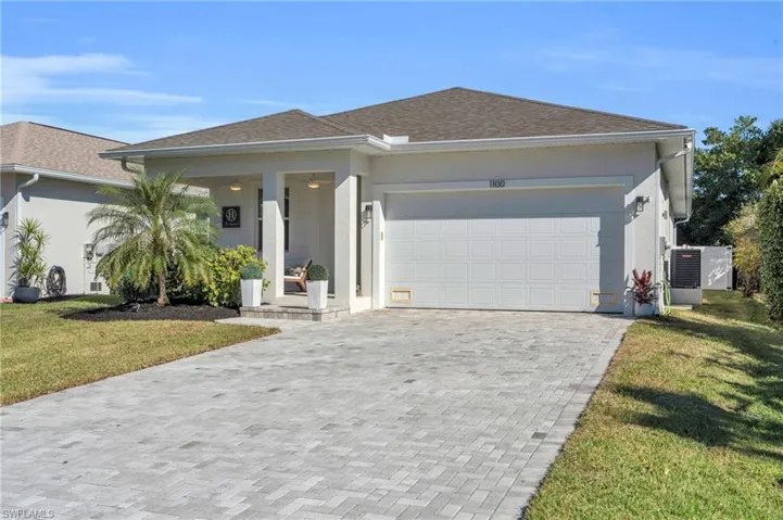 View of front of property featuring a garage and a front yard