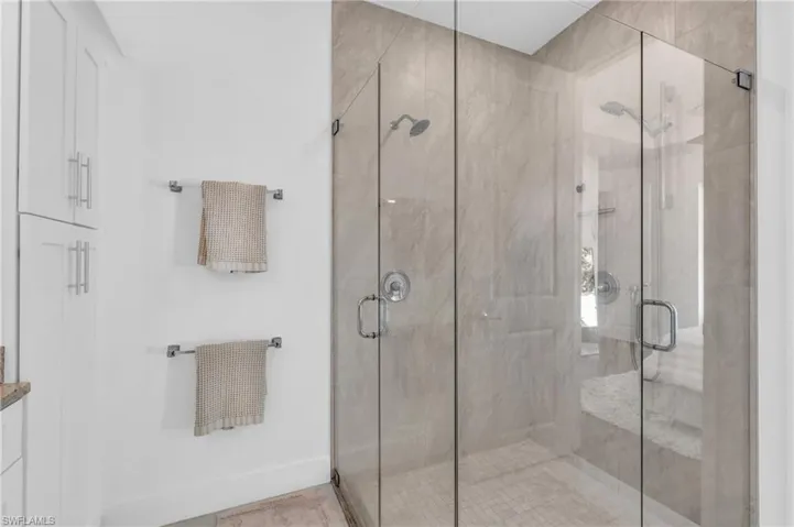 Bathroom with a glass enclosed shower with multiple shower heads