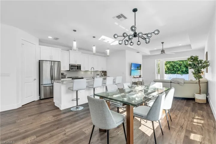 Dining area featuring dark hardwood / wood-style floors, and new lighting