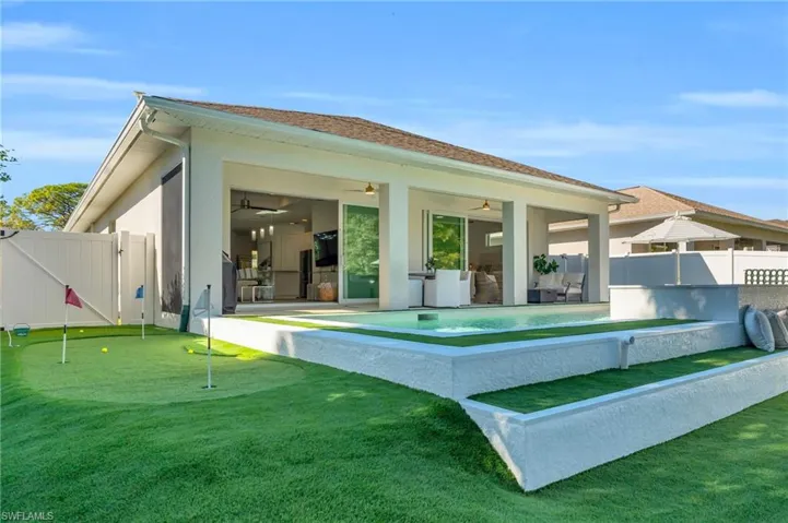 Back of house featuring a 3 hole putting and chipping green
