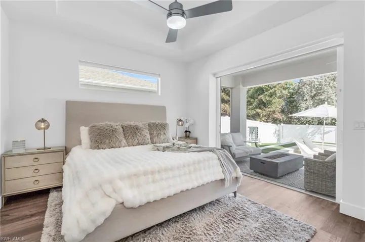 Bedroom with a raised ceiling, ceiling fan, access to outsidethrough Pocket sliders, equipped with remote controlled black out shades