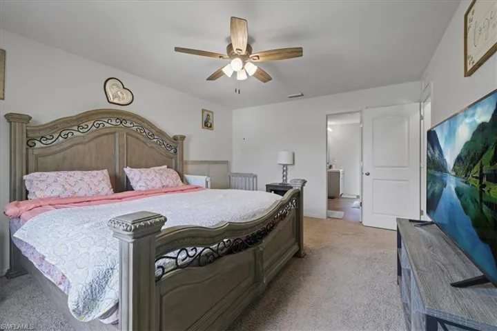 Bedroom with light colored carpet and ceiling fan