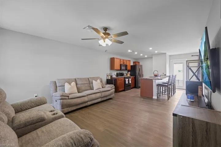 Living room featuring light wood-style floors, ceiling fan, and recessed lighting
