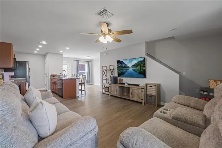 Living room featuring a ceiling fan, light wood-style floors, and recessed lighting