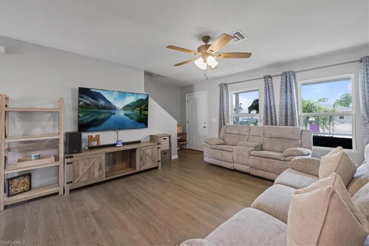 Living area with ceiling fan and wood finished floors