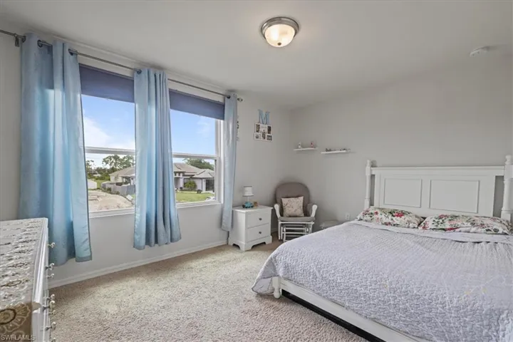 Bedroom featuring light colored carpet and baseboards