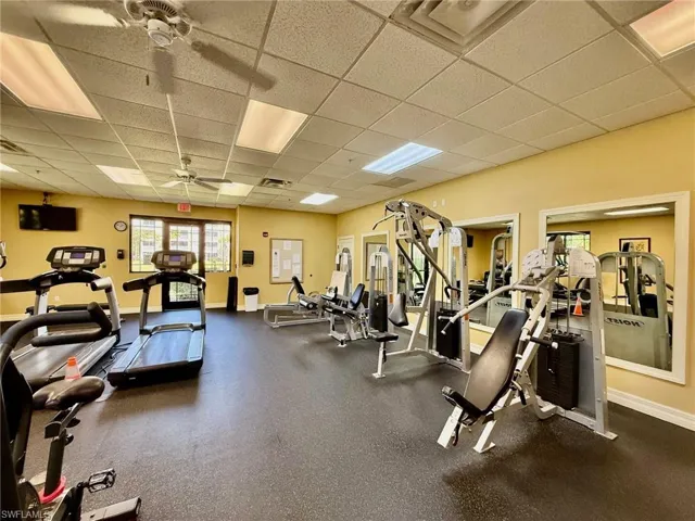 Workout area with a paneled ceiling and ceiling fan