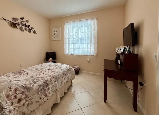 Bedroom featuring tile patterned floors and baseboards