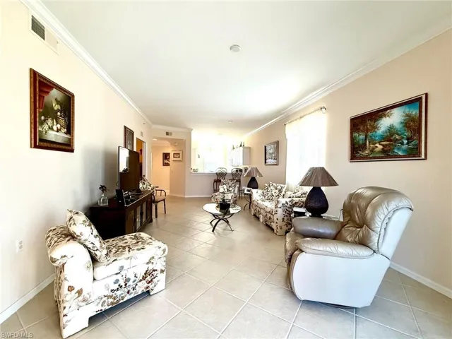 Living room featuring crown molding and light tile patterned floors