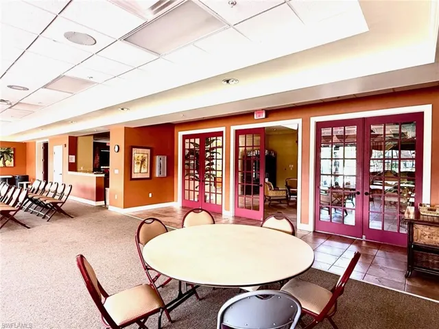 Dining area featuring french doors, a paneled ceiling, and carpet flooring