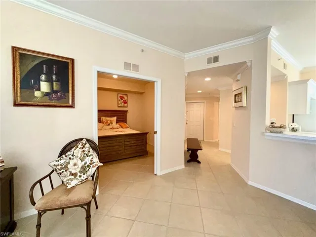 Hallway with ornamental molding and light tile patterned floors