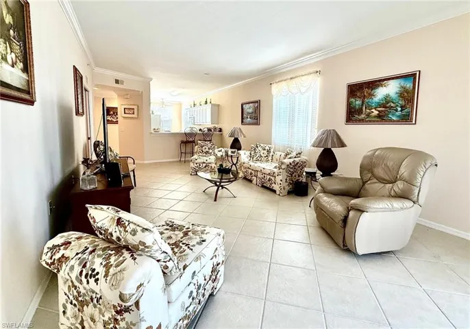 Living area featuring light tile patterned flooring and crown molding