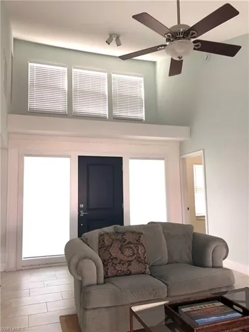 Living area featuring a high ceiling and a ceiling fan