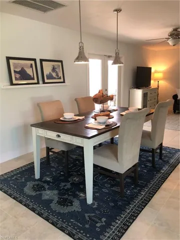 Dining area featuring light tile patterned flooring, ceiling fan, french doors, and baseboards