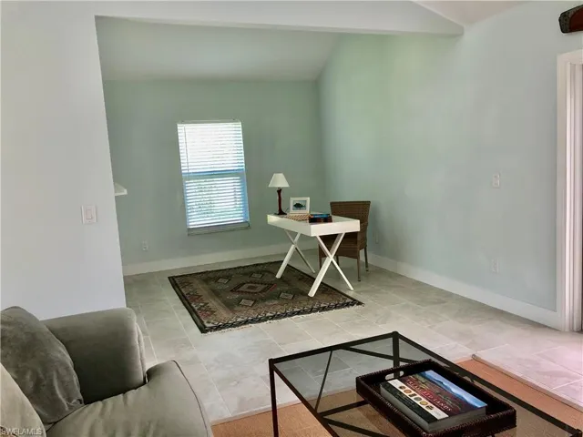 Tiled home office with baseboards and vaulted ceiling