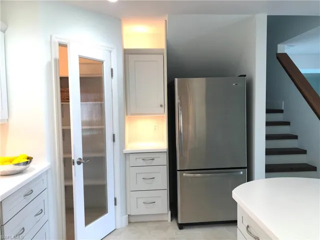 Kitchen with freestanding refrigerator, light countertops, and light tile patterned floors
