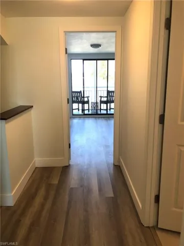Hall featuring baseboards and dark wood finished floors