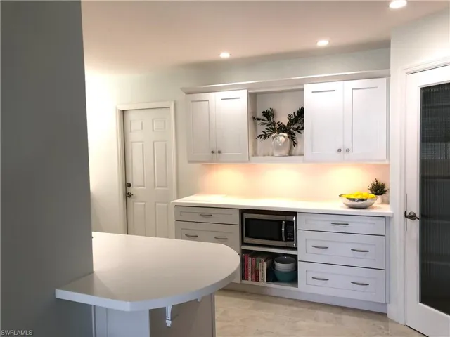 Bar area with stainless steel microwave and recessed lighting