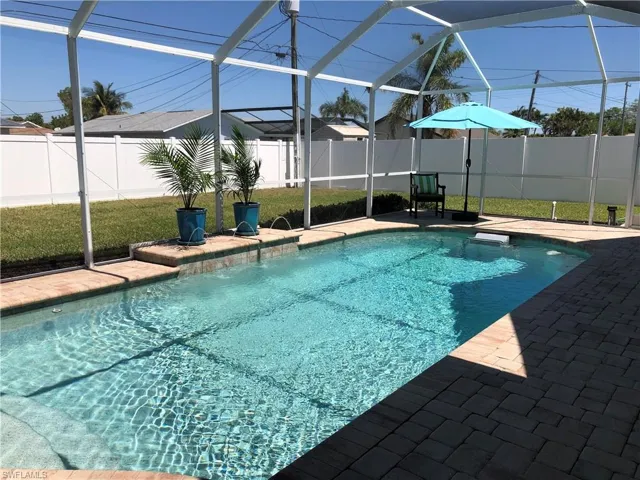 View of pool with a fenced backyard, a patio, and a lanai