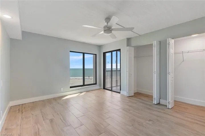 Unfurnished bedroom with multiple closets, light wood finished floors, baseboards, and a ceiling fan