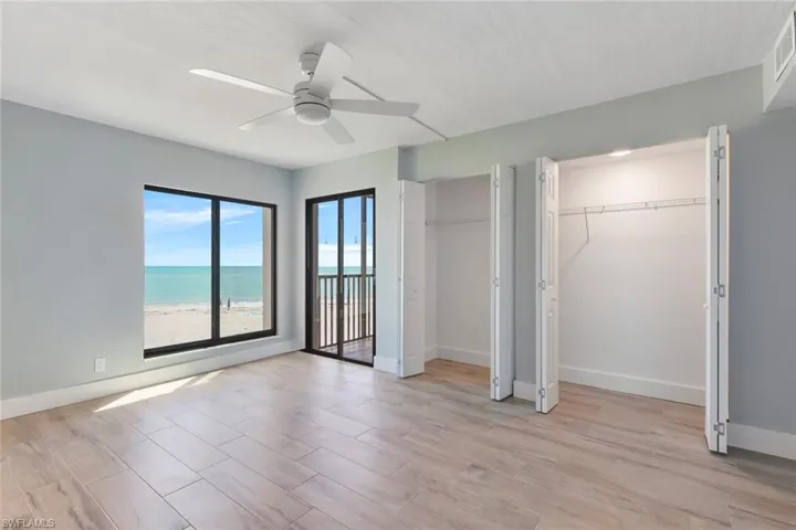 Unfurnished bedroom with visible vents, baseboards, two closets, ceiling fan, and light wood-style flooring