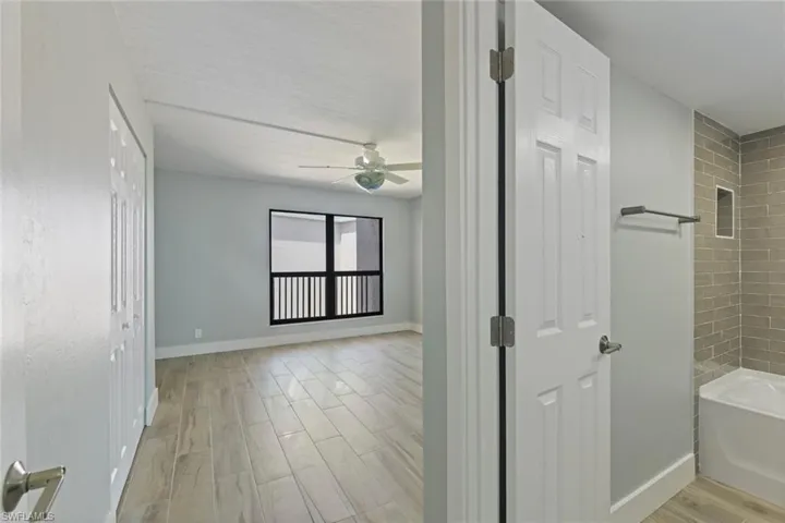 Full bathroom with baseboards, a ceiling fan, and wood finished floors